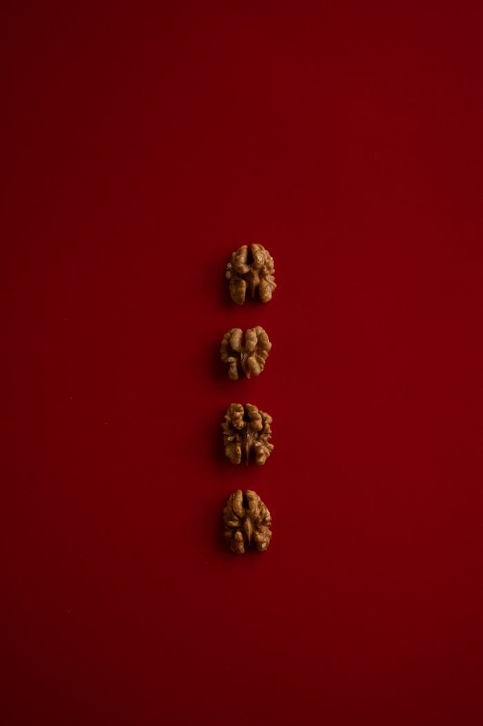 Walnuts arranged in row on red background